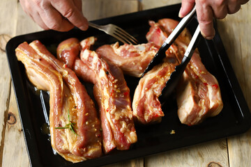 Marinated pork ribs on a pan. The chef marinates pork ribs. Barbecuing ribs.