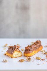 Eclair with vanilla cream, peanuts and chocolate.