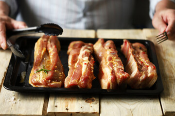 Marinated pork ribs on a pan. The chef marinates pork ribs. Barbecuing ribs.