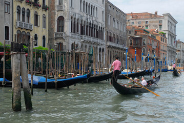 Fototapeta na wymiar Gondoliers passing moored gondolas on the Grand Canal Venice