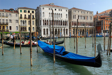 Obraz na płótnie Canvas Chatting gondoliers passing moored gondola on the Grand Canal Venice