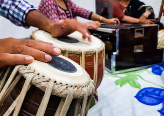 close up image of musician hand playing tabla, an indian classical music instrument with focus on front hand