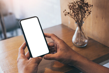 cell phone mockup blank white screen.man hand holding texting using mobile on desk at coffee shop.background empty space for advertise.work people contact marketing business,technology