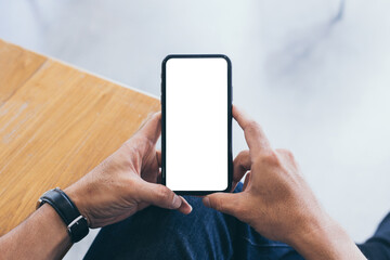 cell phone mockup blank white screen.man hand holding texting using mobile on desk at coffee shop.background empty space for advertise.work people contact marketing business,technology
