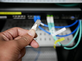 Technicians adjustment LAN cable network connected to internet switch servers in data center.
