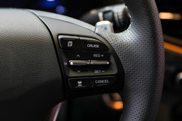 Closeup image of Korean car steering wheel with function control buttons
