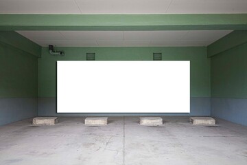 Large blank billboard on the wall of the basement car park