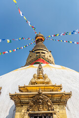Tower of the Boudhanath Stupa decorated with flags in Kathmandu, Nepal.