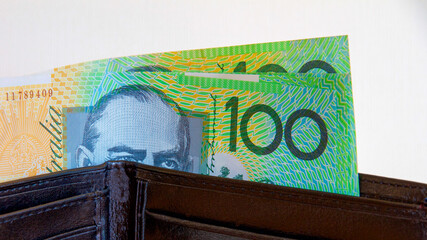Australian one hundred dollar notes in a black leather wallet.