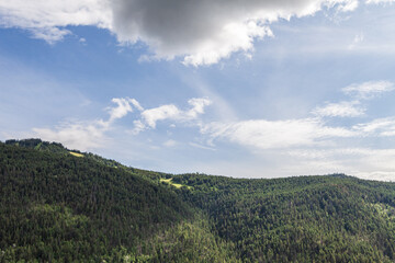 Sky with white clouds above small mountains in british columbia Canada.