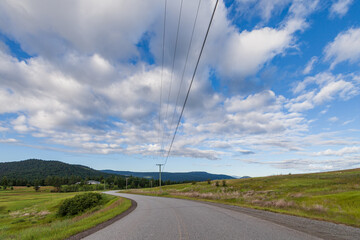 Fototapeta premium meadow near the road to the mountain under cloudy sky british columbia canada