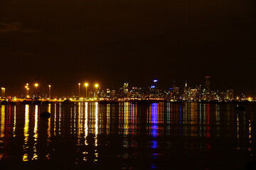 The Melbourne city skyline at night with lights on Port Phillip Bay