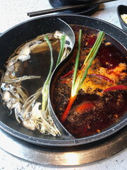 Close up of a popular Chinese Sichuan province cuisine double flavored hotpot filled with hot...