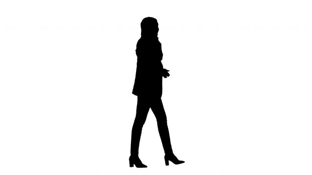 Silhouette Attractive modern muslim woman walking and talking on cell phone.