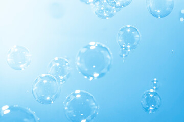 Blue soap bubbles float in the air. Freshness summer nature background.