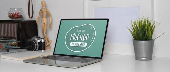 Mock up laptop on worktable with decoration in white concept home office room
