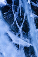 Detailed macro photo of Cracks and frozen bubbles on ice of deep lake in winter. Nature background.