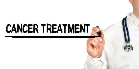 Doctor writes the word - CANCER TREATMENT. Image of a hand holding a marker isolated on a white background.