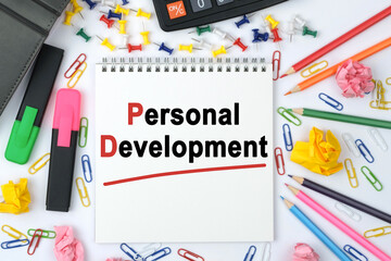 On the table is a calculator, diary, markers, pencils and a notebook with the inscription - Personal Development