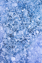 Detailed macro photo of Frozen bubbles on ice of deep lake in winter. Nature background.