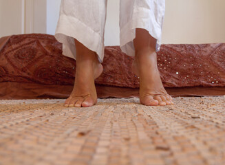 A woman on her toes on a natural leather floor rug