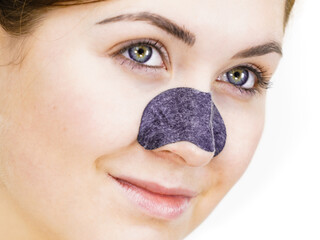 Woman applying pore strips on nose