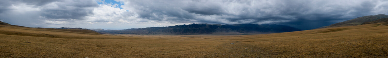 Plateau in mountains with rain clouds and mountains on background. Outdoor landscape. Sky clouds....