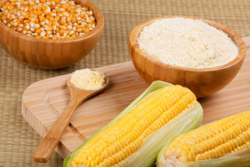 Wooden bowl of cornmeal or cornflower wirh corncobs