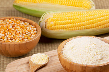 Wooden bowl of cornmeal or cornflower wirh corncobs