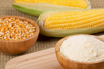 Wooden bowl of cornmeal or cornflower wirh corncobs