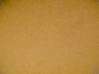 Background of textured yellow or beige plastic foam