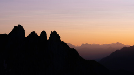 Contrast of sun rise reflected mountain range in Reflection in glacier lake of snow, cloudy sky and Bugaboo spire in Bugaboos provincial park, British Columbia, Canada in landscape
