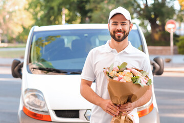 Delivery man with bouquet of beautiful flowers near car outdoors