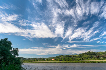 River bank and blue sky with clouds above it