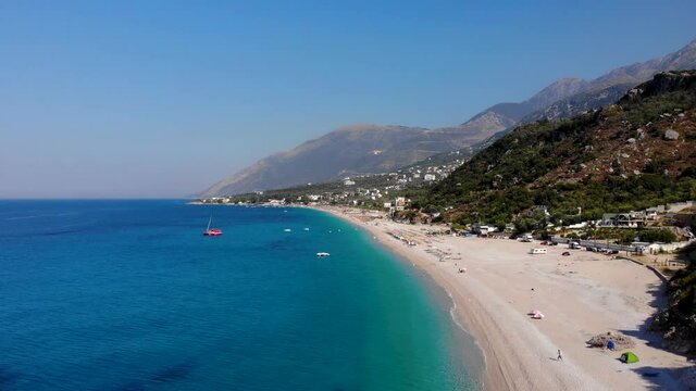 Unspoiled beach of Dhermi in Albania with sand and rocks washed by calm crystal azure sea water