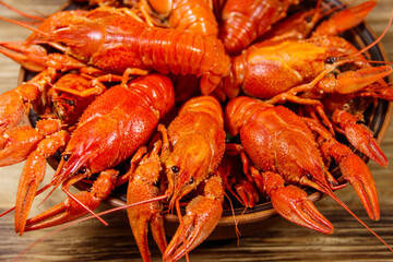 Boiled crayfish in plate on wooden table