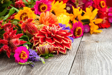 Holiday autumn bouquet. Frame of colorful flowers arranged on old wooden background. Copy space for...