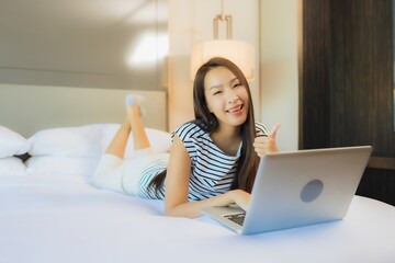 Portrait beautiful young asian woman use computer laptop on bed