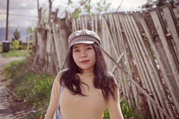 Asian Model Posing By A Dilapidated Fence