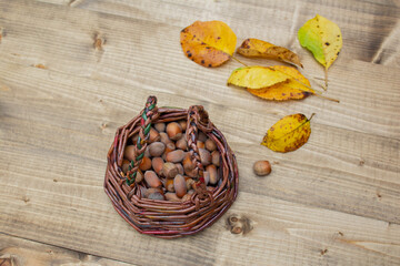 small wicker basket with nuts on a wooden table / concept of village culture, care for nature