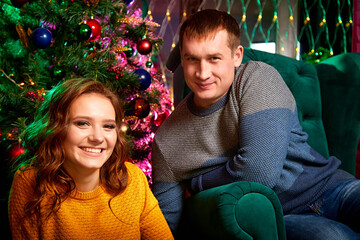 Fototapeta premium Happy couple in love in the room decorated for Christmas or New Year.
