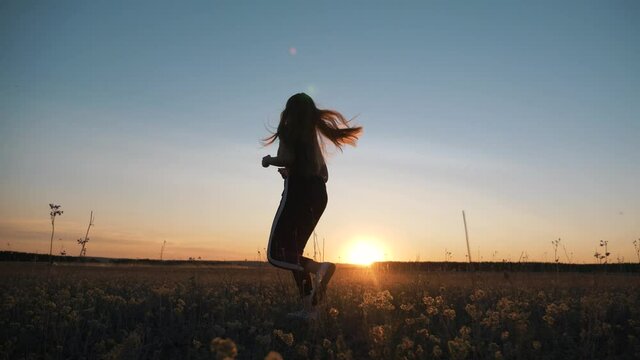 The girl runs in the park on the grass. Girl runner at sunset. Fitness girls training. Grass runners training. active lifestyle, cardio jogging outdoors. Sporty girl jogging on the grass in the park