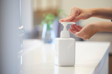 アルコール除菌をする女性の手元