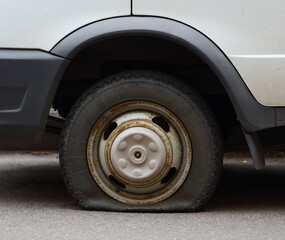 Fototapeta na wymiar Punctured wheel of a small car