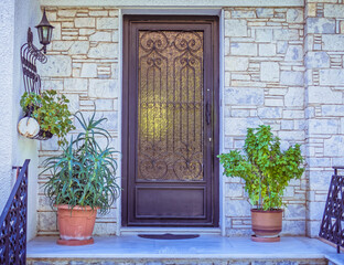 Fototapeta na wymiar contemporary house entrance metal and glass door and potted plants, Athens Greece