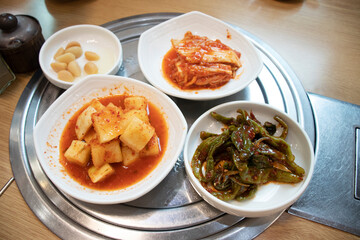 Bowls of Meal Side Dishes of Spicy radish, Cabbage and Pepper, Garlic. Korean side dishes.