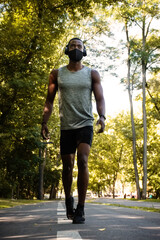 Fit male African jogger wearing face mask