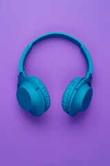 Fototapeta na wymiar Cool blue wireless headphone on purple background. Music concept.