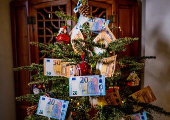 Un ricco albero di Natale addobbato con tante  banconote 