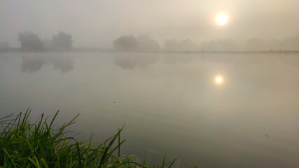 Fishing lake in the foggy morning
